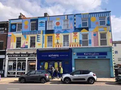 a colorful building with cars parked in front of it at Aqua View, New Brighton Beach - 1 bedroom with BALCONY & VIEW in New Brighton