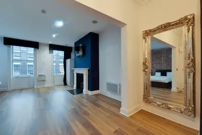 a living room with a mirror and a bed at 9 Rodney Townhouse in Liverpool