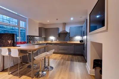 a kitchen with a table and some chairs in it at 9 Rodney Townhouse in Liverpool