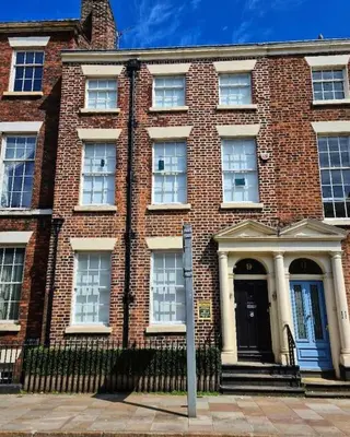 a large brick building with a black door at 9 Rodney Townhouse in Liverpool