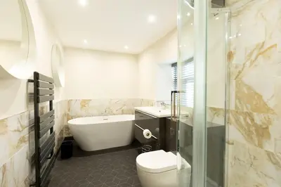 a bathroom with a tub and a toilet and a sink at OLD BANK HOUSE - Perfect Getaway for Friends & Families in Holker