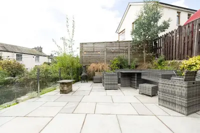 a patio with chairs and a table and a fence at OLD BANK HOUSE - Perfect Getaway for Friends & Families in Holker
