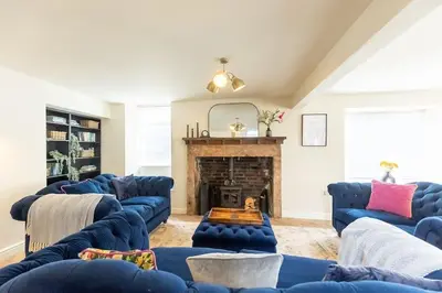 a living room with blue couches and a fireplace at OLD BANK HOUSE - Perfect Getaway for Friends & Families in Holker