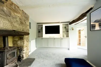 a living room with a fireplace and a television at OLD BANK HOUSE - Perfect Getaway for Friends & Families in Holker