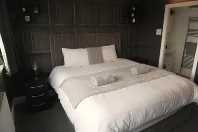 a bedroom with a large bed with towels on it at Detached Homestay - Super, King & Double Rooms - Leyland, Preston, Chorley, Lancashire in Leyland