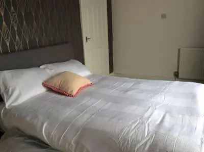 a large white bed with a pillow on it at 2 bedroom apartment in Horwich