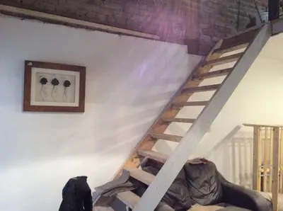 a wooden staircase in a room with a wall at 2 bedroom apartment in Horwich