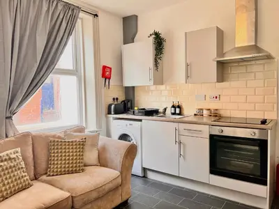 a living room with a couch and a kitchen at Apartment 2 in Blackpool