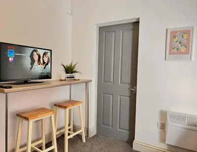 a room with a desk with a computer and two stools at Apartment 2 in Blackpool