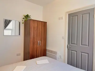 a bedroom with a bed and a wooden cabinet at Apartment 2 in Blackpool