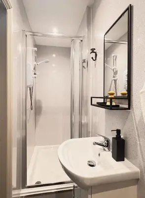 a white bathroom with a sink and a shower at Apartment 2 in Blackpool