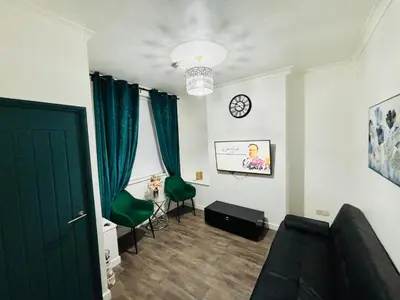 a living room with a couch and a clock on the wall at ENTIRE LUXURY HOUSE near CITY CENTRE - FREE PARKING in Liverpool