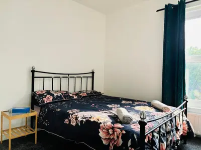 a bedroom with a bed with a floral comforter at ENTIRE LUXURY HOUSE near CITY CENTRE - FREE PARKING in Liverpool