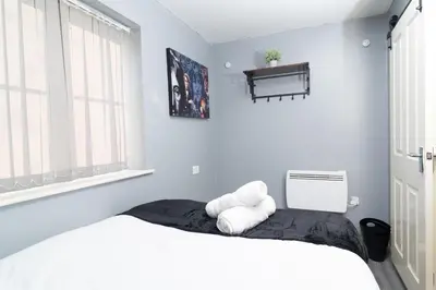 a bedroom with a bed with two pillows on it at City Haven Modern 3 Bedroom Apartment with Private Parking in Liverpool