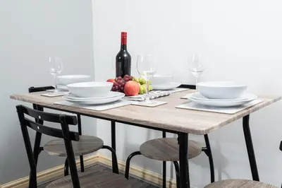 a wooden table with a plate of food and a bottle of wine at City Haven Modern 3 Bedroom Apartment with Private Parking in Liverpool