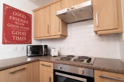 a kitchen with a stove and a sign on the wall at City Haven Modern 3 Bedroom Apartment with Private Parking in Liverpool