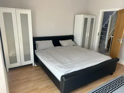 a bed with a black frame in a room at Entire Seaside Home 6 Private Bedrooms Sleeps 10 in Wallasey