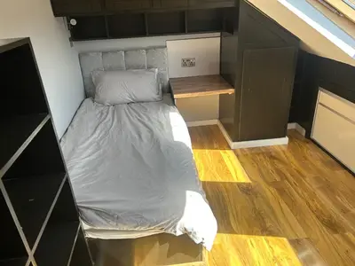 a bed in a small room with a bed in it at Entire Seaside Home 6 Private Bedrooms Sleeps 10 in Wallasey