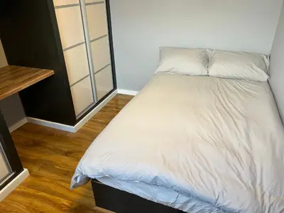 a small bedroom with a bed with white sheets at Entire Seaside Home 6 Private Bedrooms Sleeps 10 in Wallasey