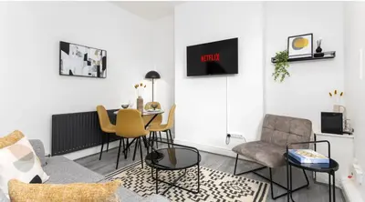 a living room with a table and chairs at Residency apartments Sefton road in Walton on the Hill