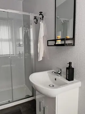 a white bathroom with a sink and a shower at Apartment 3 in Blackpool