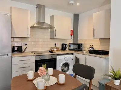 a kitchen with a table and a dishwasher at Apartment 3 in Blackpool