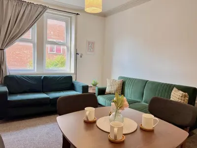 a living room with a green couch and a table at Apartment 3 in Blackpool