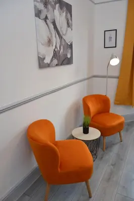 two orange chairs and a table in a room at Modern Retreat Your Birkenhead Heaven, A Peaceful Getaway in Birkenhead