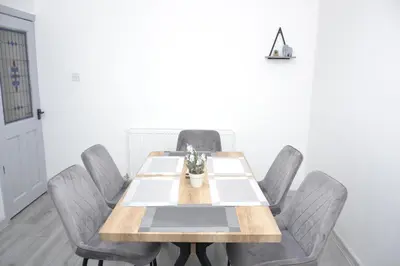 a dining room with a wooden table and chairs at Modern Retreat Your Birkenhead Heaven, A Peaceful Getaway in Birkenhead