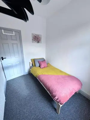 a bedroom with a bed with a pink and yellow blanket at Modern Retreat Your Birkenhead Heaven, A Peaceful Getaway in Birkenhead