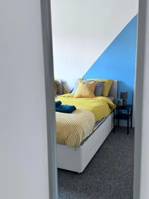 a bedroom with a bed with yellow sheets and pillows at Modern Retreat Your Birkenhead Heaven, A Peaceful Getaway in Birkenhead