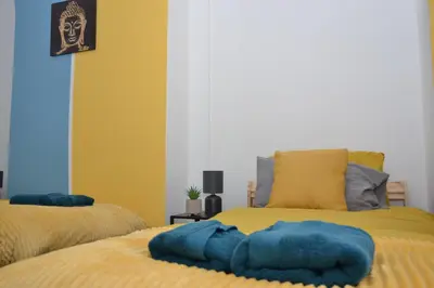 a bedroom with two beds with blue and yellow at Modern Retreat Your Birkenhead Heaven, A Peaceful Getaway in Birkenhead