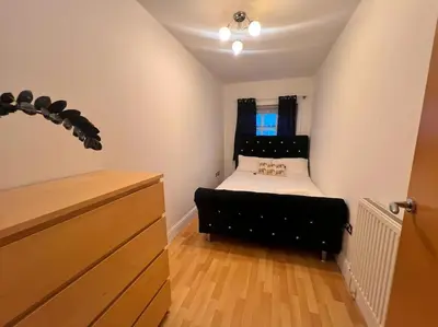 a bedroom with a bed with a black headboard at Cosy 2bed City Centre Flat! in Liverpool
