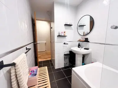 a white bathroom with a sink and a mirror at Cosy 2bed City Centre Flat! in Liverpool