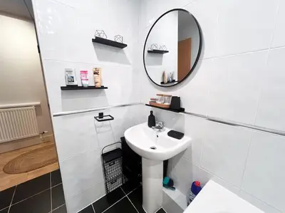 a white bathroom with a sink and a mirror at Cosy 2bed City Centre Flat! in Liverpool