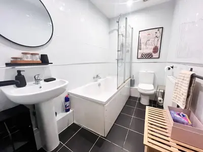 a white bathroom with a sink and a toilet at Cosy 2bed City Centre Flat! in Liverpool