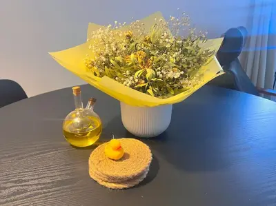 a table with a bouquet of flowers and a vase at Cosy 2bed City Centre Flat! in Liverpool