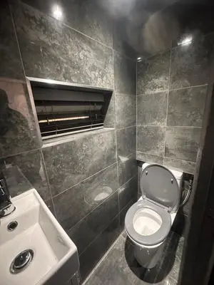 a bathroom with a white toilet and a sink at 3 BR- Central Wigan- HOT TUB in Ince-in-Makerfield