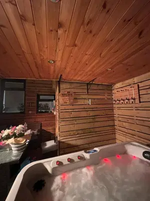 a bath tub in a room with a wooden ceiling at 3 BR- Central Wigan- HOT TUB in Ince-in-Makerfield