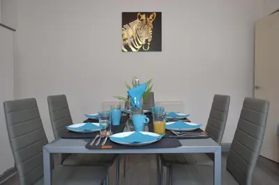 a dining room table with blue plates and glasses at Stylish Retreat near Birkenhead & Liverpool Your Cozy Home Away From Home in Wallasey