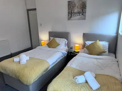 two beds sitting next to each other in a bedroom at Stylish Retreat near Birkenhead & Liverpool Your Cozy Home Away From Home in Wallasey