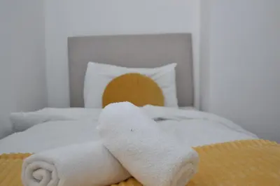 a bed with two white towels on it at Stylish Retreat near Birkenhead & Liverpool Your Cozy Home Away From Home in Wallasey
