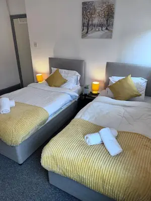 two beds sitting next to each other in a room at Stylish Retreat near Birkenhead & Liverpool Your Cozy Home Away From Home in Wallasey