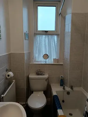 a bathroom with a toilet and a sink and a window at Heatherlea in Grange Over Sands