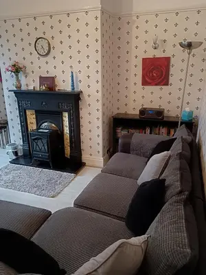 a living room with three couches and a fireplace at Heatherlea in Grange Over Sands
