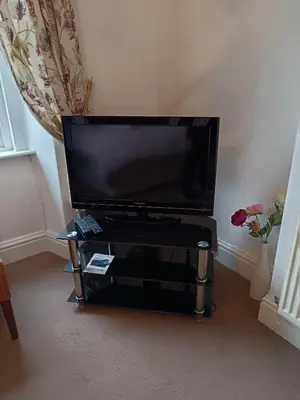a flat screen tv sitting on a stand in a living room at Heatherlea in Grange Over Sands