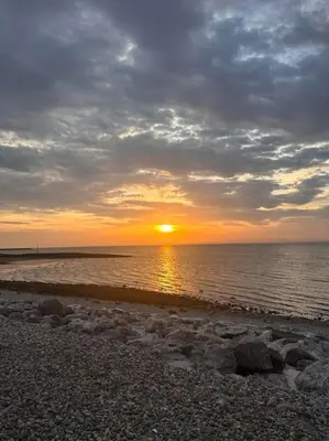 a sunset on a beach with the sun setting at 3 bed home in Bolton Le Sands in Bolton le Sands