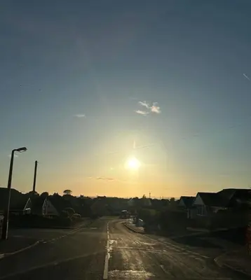 an empty street with the sun in the sky at 3 bed home in Bolton Le Sands in Bolton le Sands