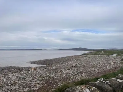 a rocky beach with a large body of water at 3 bed home in Bolton Le Sands in Bolton le Sands