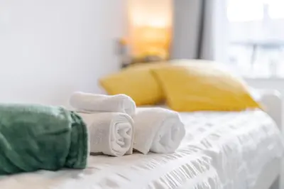 a pile of towels sitting on top of a bed at The Old Bike Shop Flat 2 in Heapey